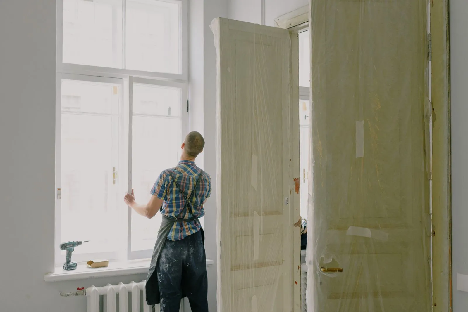 Installer fitting glass into a commercial door and window opening
