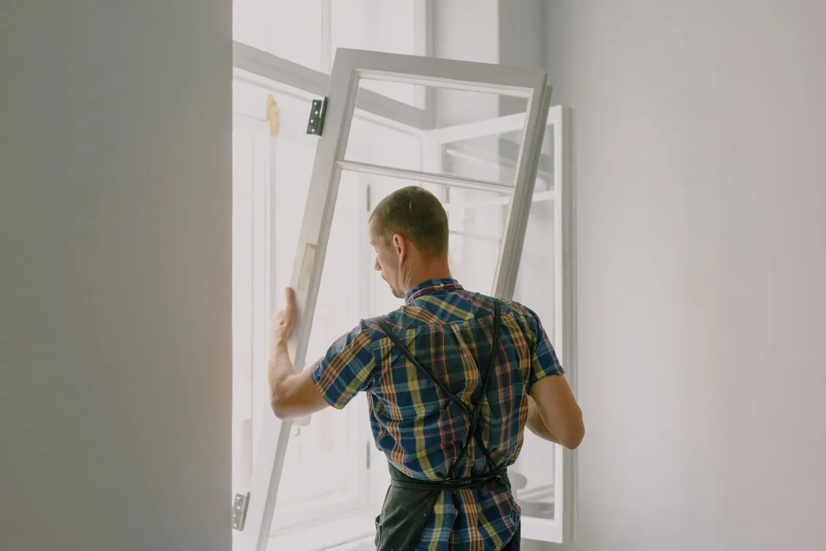 Installer mounting a replacement window into an existing opening in a Mesa home